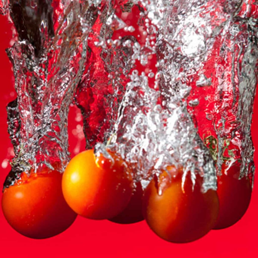 Strobistfotografie van tomaten in water
